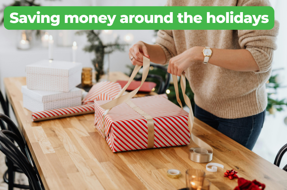 A woman in a beige sweater wraps a holiday gift on a table. Text over the image reads, "Saving money around the holidays"
